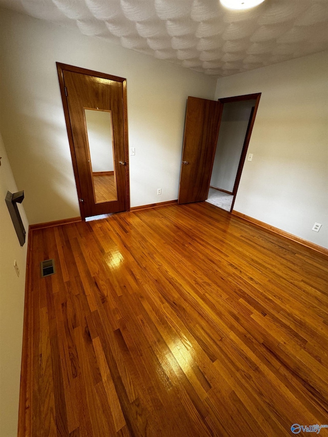 unfurnished bedroom featuring hardwood / wood-style flooring