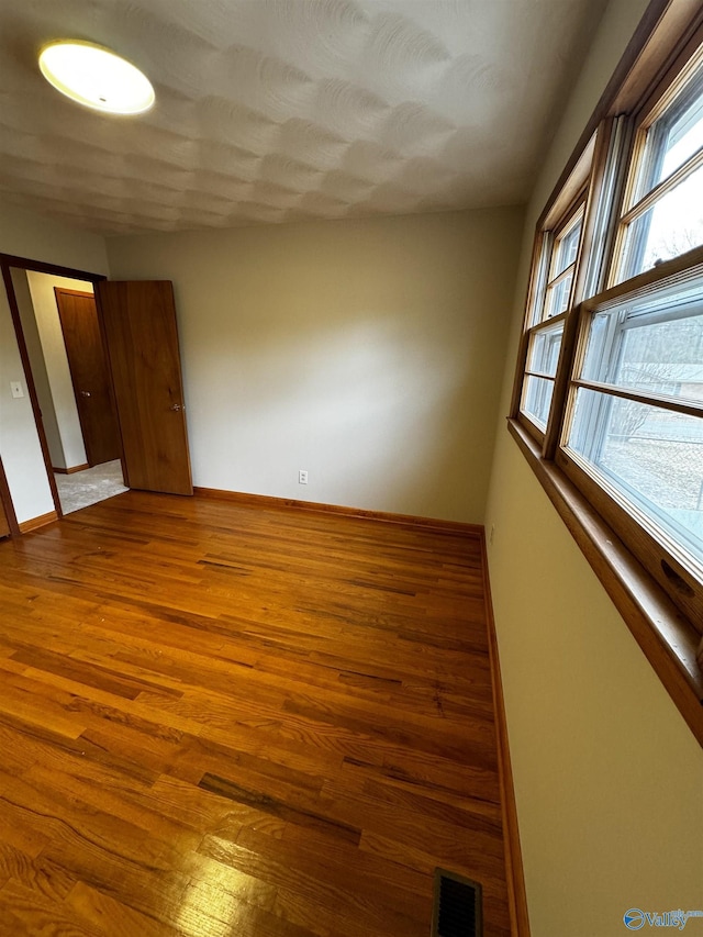 unfurnished room with wood-type flooring