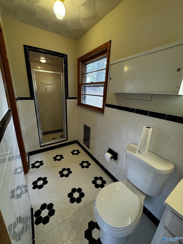 bathroom with tile walls, vanity, an enclosed shower, toilet, and a textured ceiling