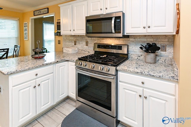 kitchen featuring tasteful backsplash, a peninsula, appliances with stainless steel finishes, and crown molding