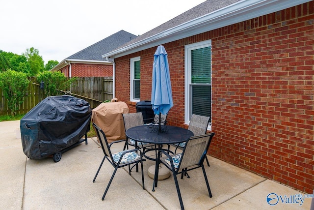 view of patio with fence, outdoor dining space, and grilling area