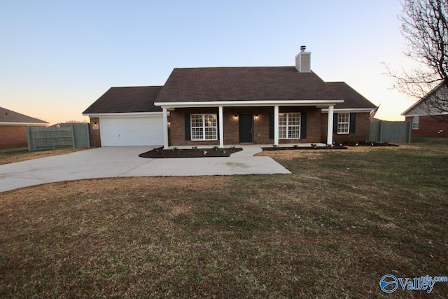 ranch-style home with brick siding, a yard, a chimney, fence, and driveway