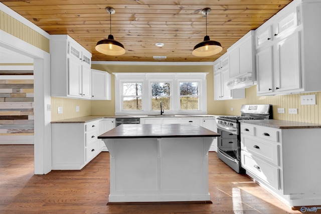 kitchen featuring white cabinets, stainless steel appliances, and decorative light fixtures