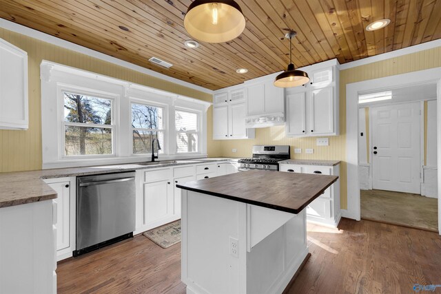 kitchen featuring appliances with stainless steel finishes, wooden ceiling, white cabinetry, and pendant lighting