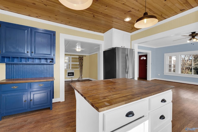 kitchen featuring wood counters, stainless steel fridge, blue cabinets, and pendant lighting