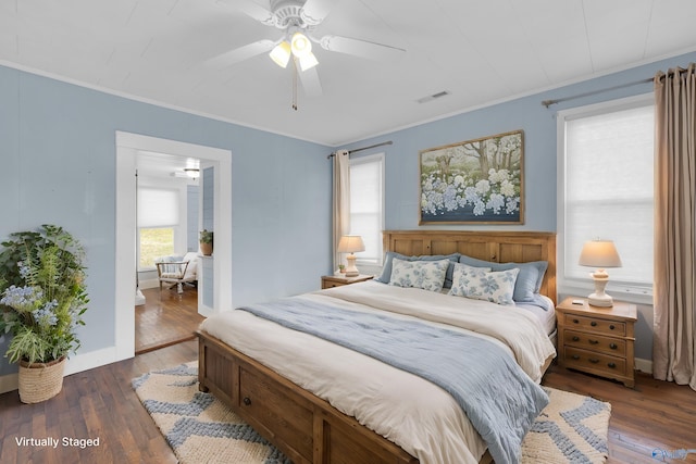 bedroom featuring ceiling fan, ornamental molding, and dark wood-type flooring