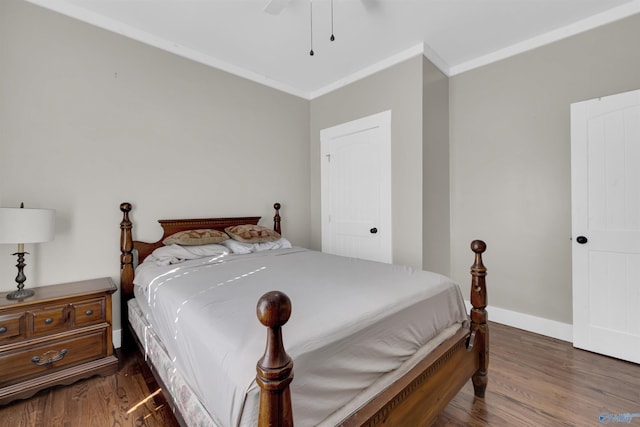 bedroom featuring dark hardwood / wood-style flooring, ceiling fan, and crown molding