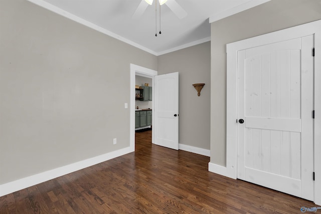 unfurnished bedroom with ceiling fan, dark wood-type flooring, and ornamental molding