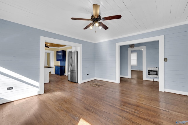 unfurnished living room with ceiling fan, dark hardwood / wood-style flooring, heating unit, crown molding, and a fireplace