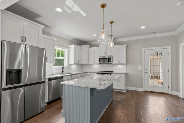 kitchen with a sink, a center island, white cabinetry, and stainless steel appliances