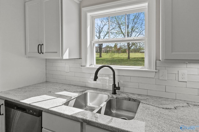 kitchen featuring a sink, backsplash, dishwasher, and a healthy amount of sunlight