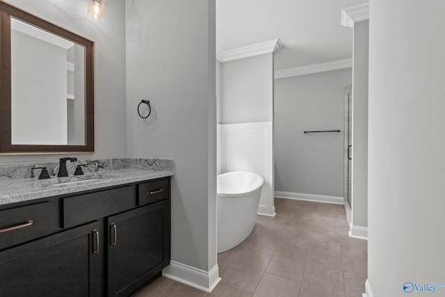 bathroom featuring ornamental molding, baseboards, a freestanding bath, and vanity