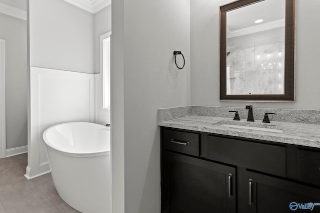 bathroom featuring a freestanding tub, vanity, ornamental molding, tile patterned flooring, and baseboards
