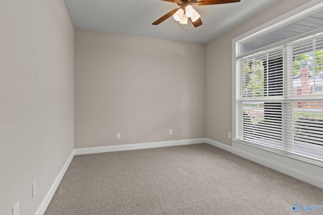 carpeted empty room with ceiling fan and baseboards