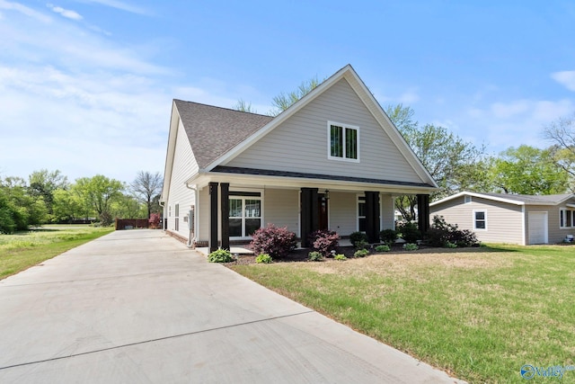 bungalow with roof with shingles, a front yard, a porch, and driveway