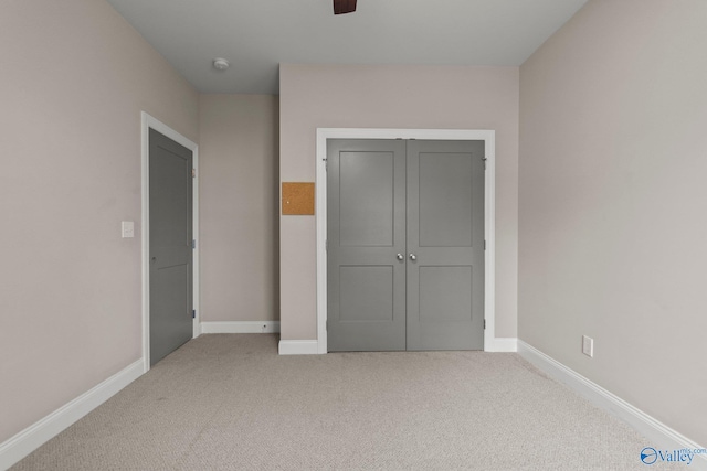 unfurnished bedroom with a closet, baseboards, and carpet flooring