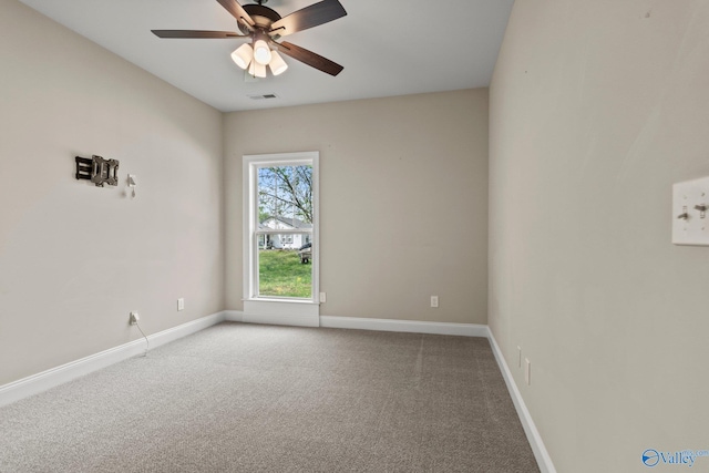 carpeted spare room with visible vents, ceiling fan, and baseboards