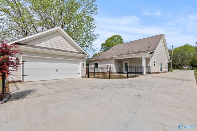 view of home's exterior featuring a garage, driveway, an outdoor structure, and fence