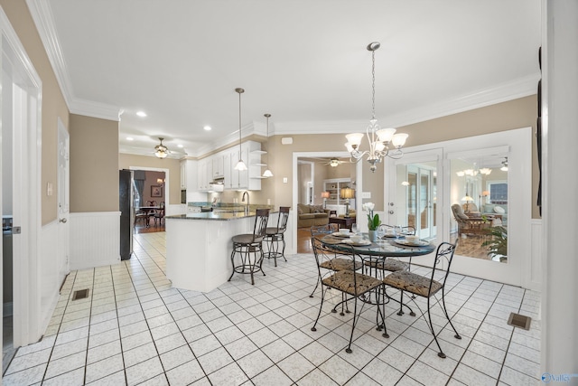 dining space featuring light tile patterned flooring, ornamental molding, and ceiling fan with notable chandelier