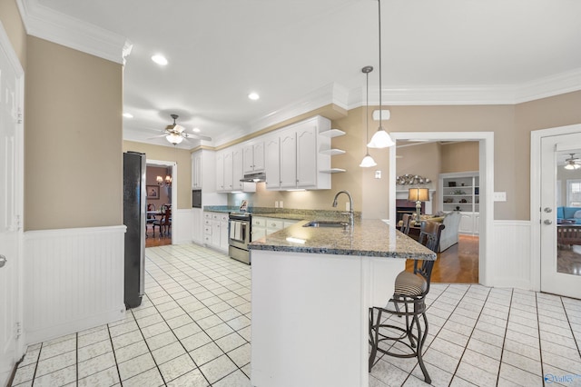 kitchen featuring white cabinetry, sink, appliances with stainless steel finishes, kitchen peninsula, and decorative light fixtures