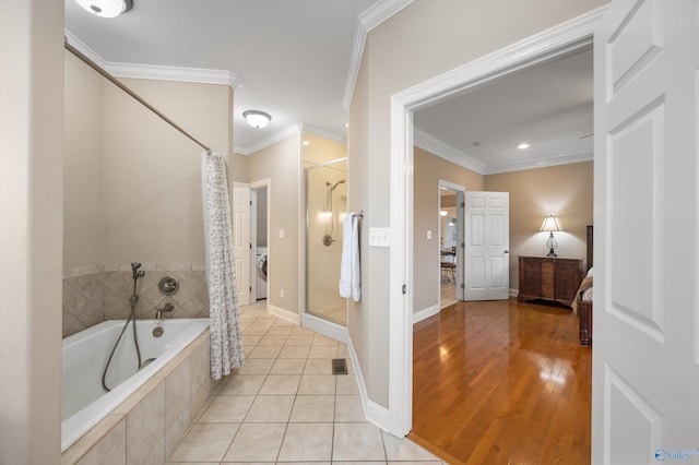 bathroom with wood-type flooring, washer / clothes dryer, plus walk in shower, and crown molding