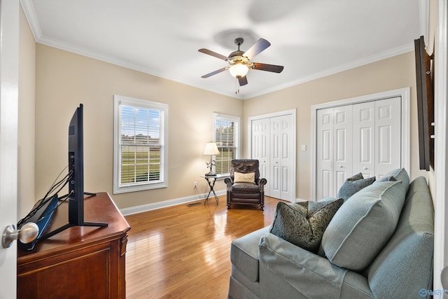 living room featuring ornamental molding, light hardwood / wood-style flooring, and ceiling fan