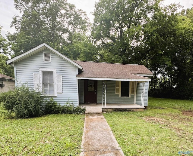 view of front of house featuring roof with shingles, a porch, and a front lawn