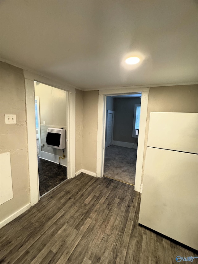 interior space with heating unit, baseboards, and dark wood-style flooring