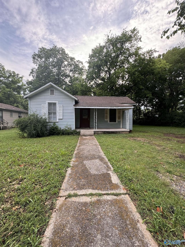 single story home featuring a porch and a front yard