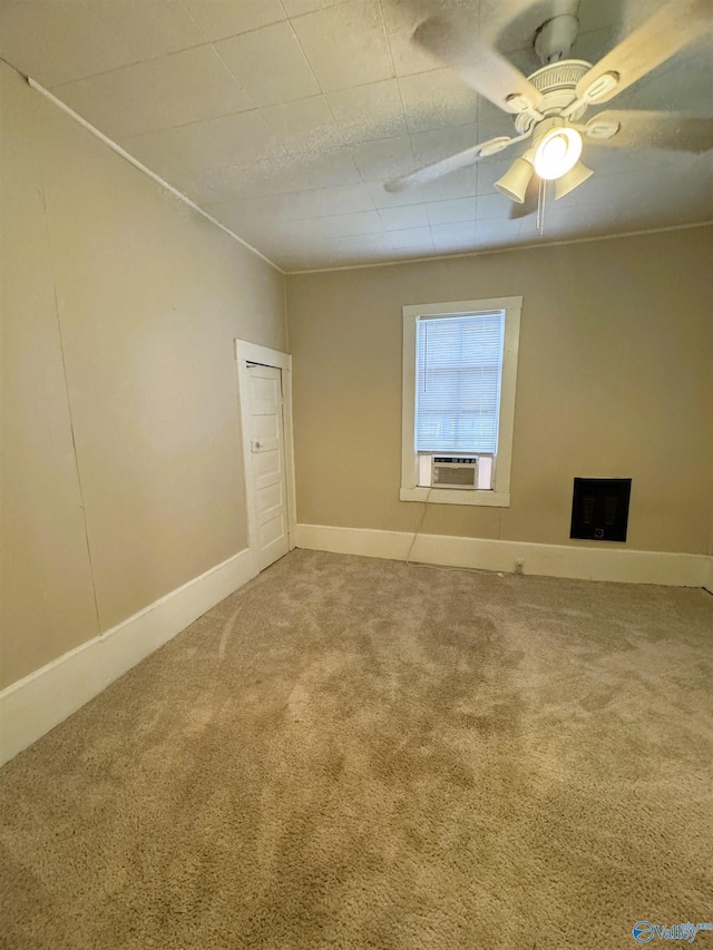 spare room featuring carpet floors, baseboards, and cooling unit