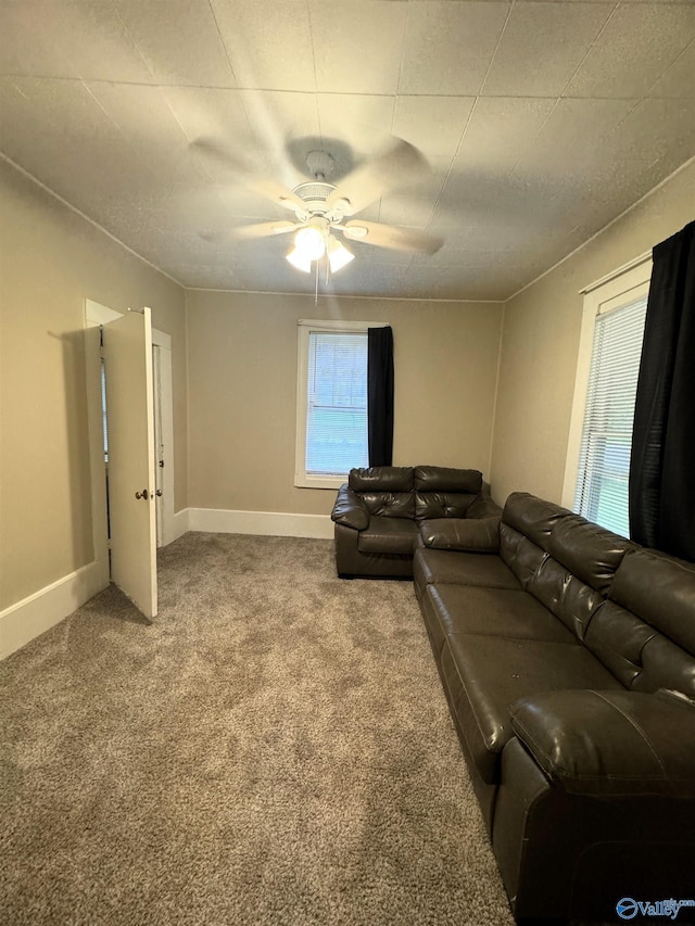 living area with baseboards, carpet, and ceiling fan