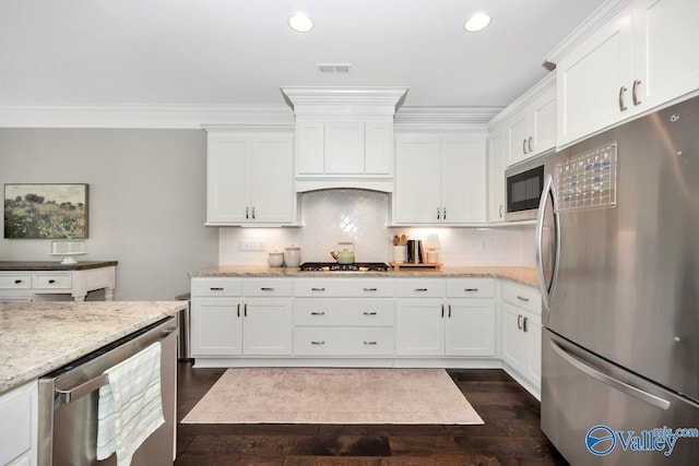 3011 Chimney Cove Cir, Brownsboro, AL 35741 - kitchen featuring appliances with stainless steel finishes, white cabinets, dark wood-type flooring, light stone countertops, and ornamental molding