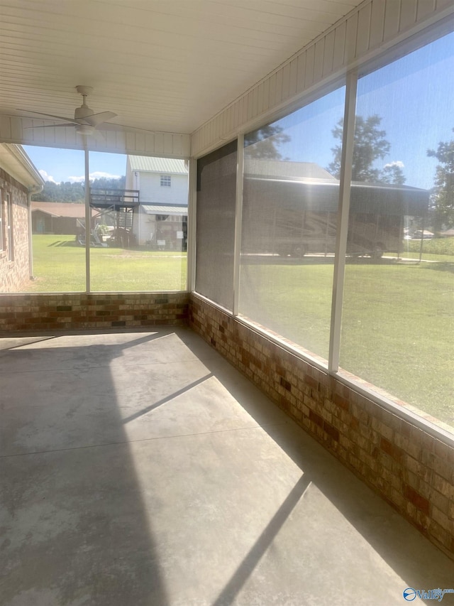 unfurnished sunroom with ceiling fan