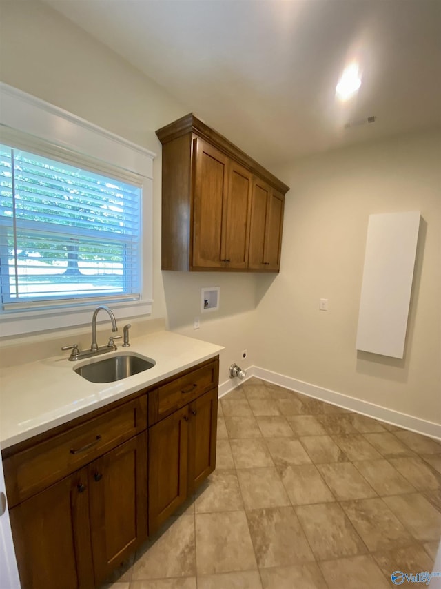 kitchen with visible vents, baseboards, light countertops, and a sink