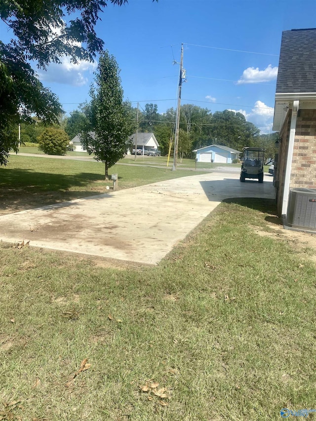 view of yard with a garage and central air condition unit