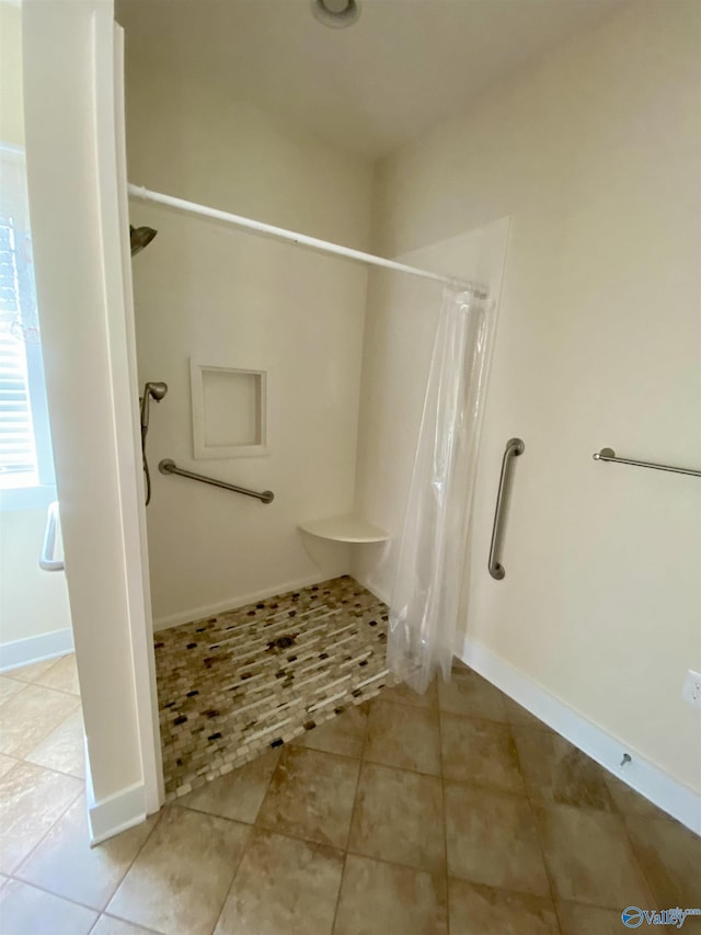 bathroom with a shower with shower curtain, tile patterned flooring, and baseboards