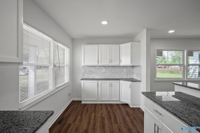 2707 Morgan St SW, Huntsville, AL 35805 - kitchen featuring dark stone counters, dark wood-style flooring, decorative backsplash, visible vents, and white cabinetry