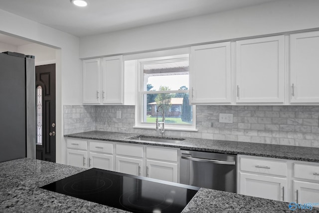 2707 Morgan St SW, Huntsville, AL 35805 - kitchen featuring dark stone counters, a sink, appliances with stainless steel finishes, and white cabinetry