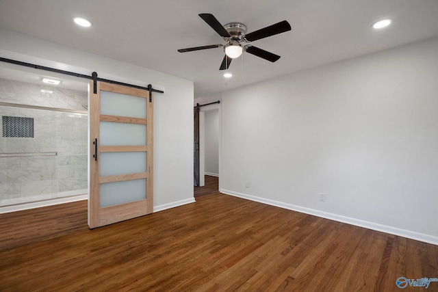 2707 Morgan St SW, Huntsville, AL 35805 - unfurnished bedroom with recessed lighting, wood finished floors, a barn door, and baseboards