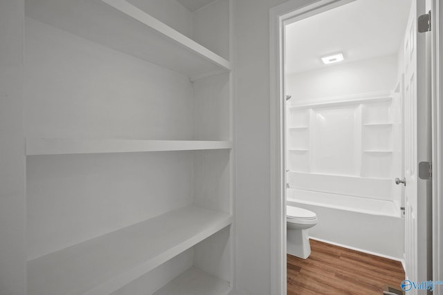 2707 Morgan St SW, Huntsville, AL 35805 - bathroom featuring wood finished floors, toilet, and shower / washtub combination