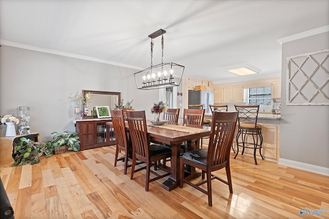 dining area featuring light hardwood / wood-style floors and crown molding