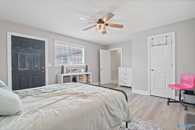 bedroom with ceiling fan, a textured ceiling, and light hardwood / wood-style flooring