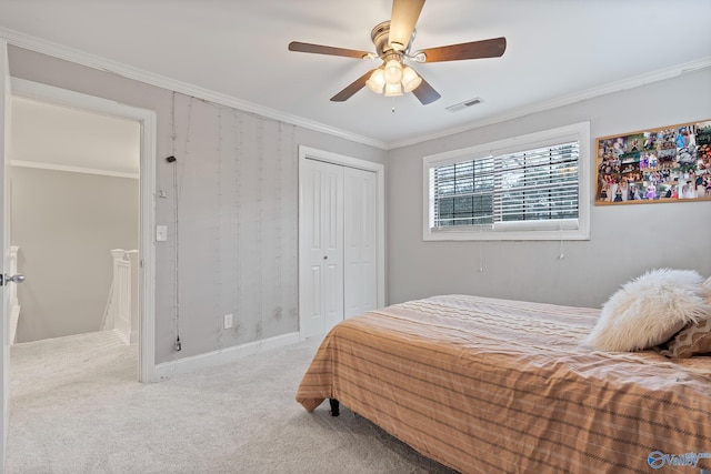 carpeted bedroom with crown molding, a closet, and ceiling fan