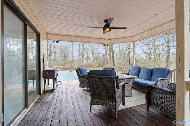 wooden terrace with an outdoor living space and ceiling fan