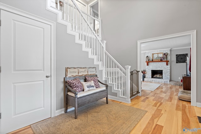 stairway featuring a fireplace, hardwood / wood-style floors, and crown molding