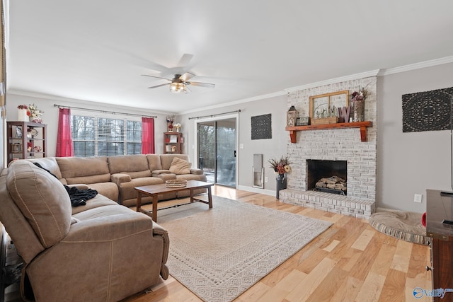 living room with crown molding, hardwood / wood-style flooring, ceiling fan, and a brick fireplace