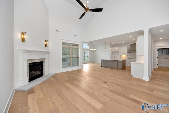 unfurnished living room with ceiling fan, baseboards, and a fireplace
