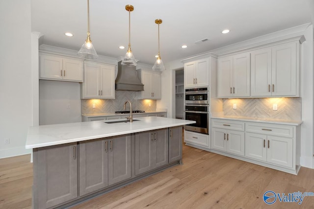 kitchen featuring visible vents, stainless steel double oven, custom exhaust hood, and tasteful backsplash