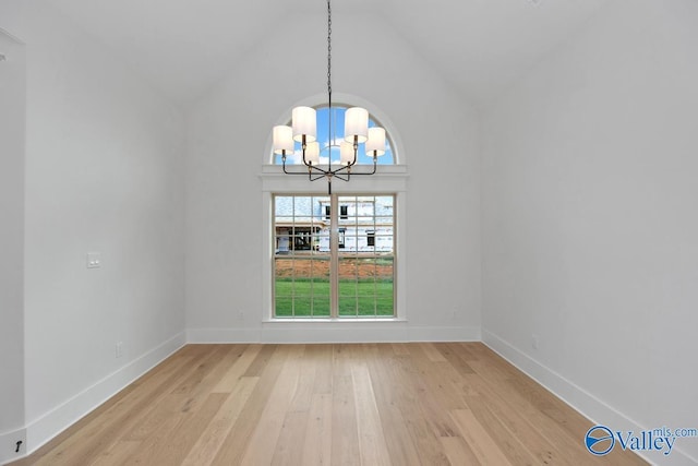 unfurnished dining area featuring high vaulted ceiling, baseboards, a chandelier, and light wood-style floors