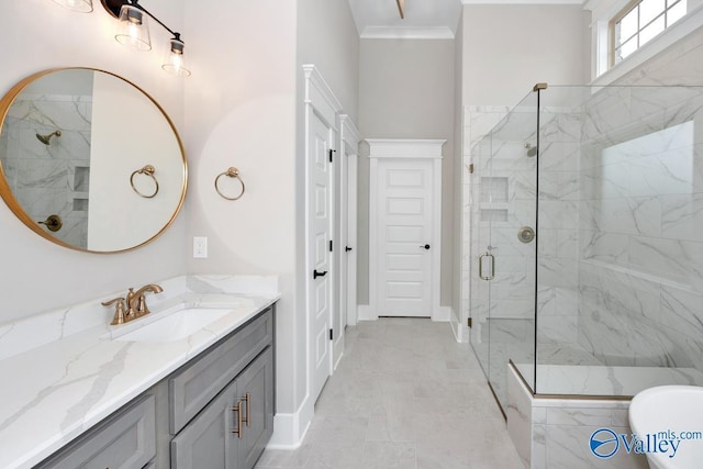 bathroom with baseboards, ornamental molding, vanity, and a stall shower